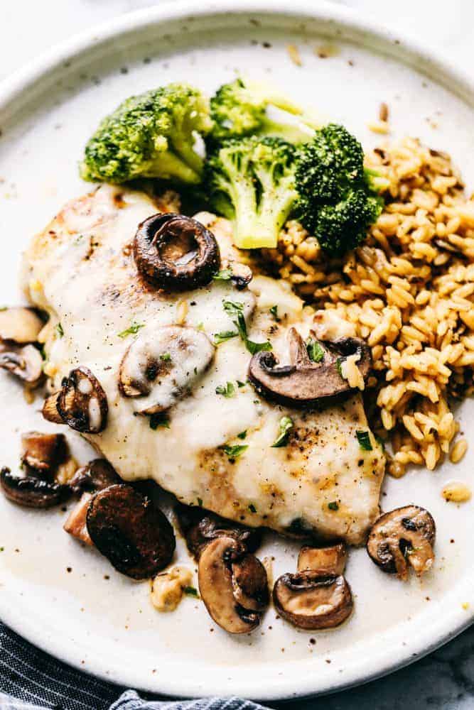 Easy Baked Cheesy Mushroom Chicken on a plate with rice and broccoli.