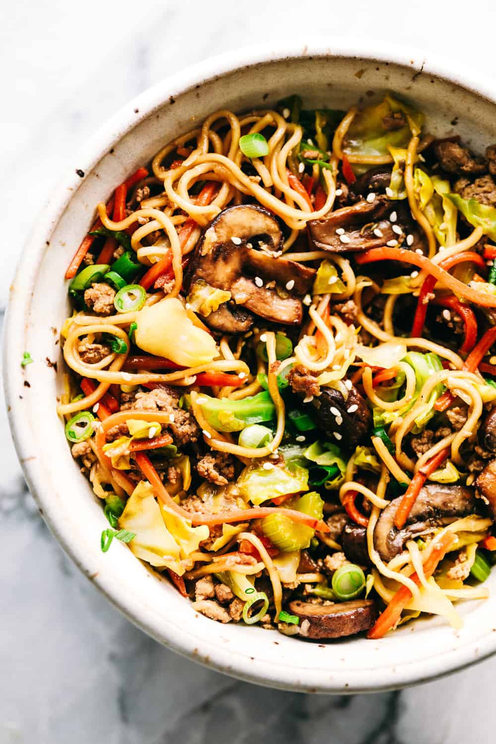 Egg roll noodles with ground pork in a white dish.