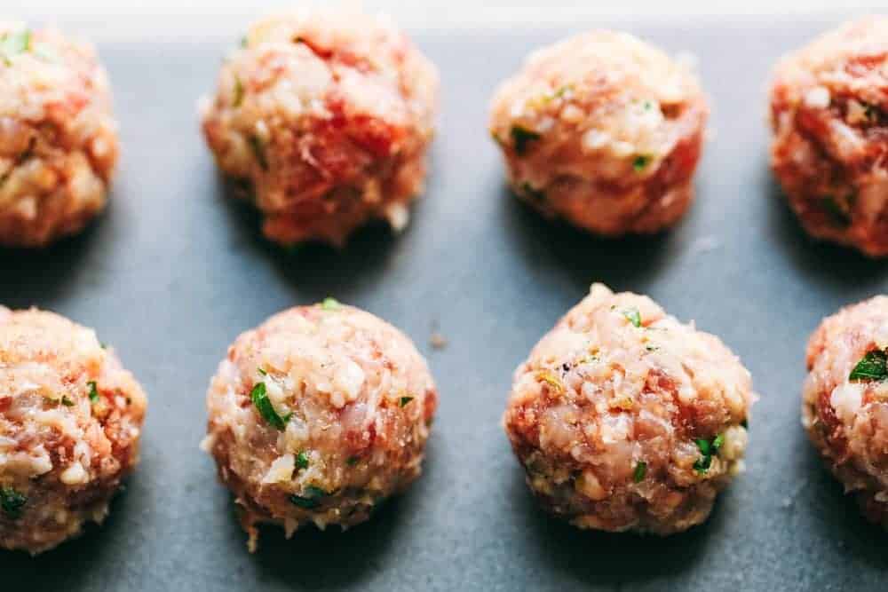 Raw meatballs on a sheet pan.