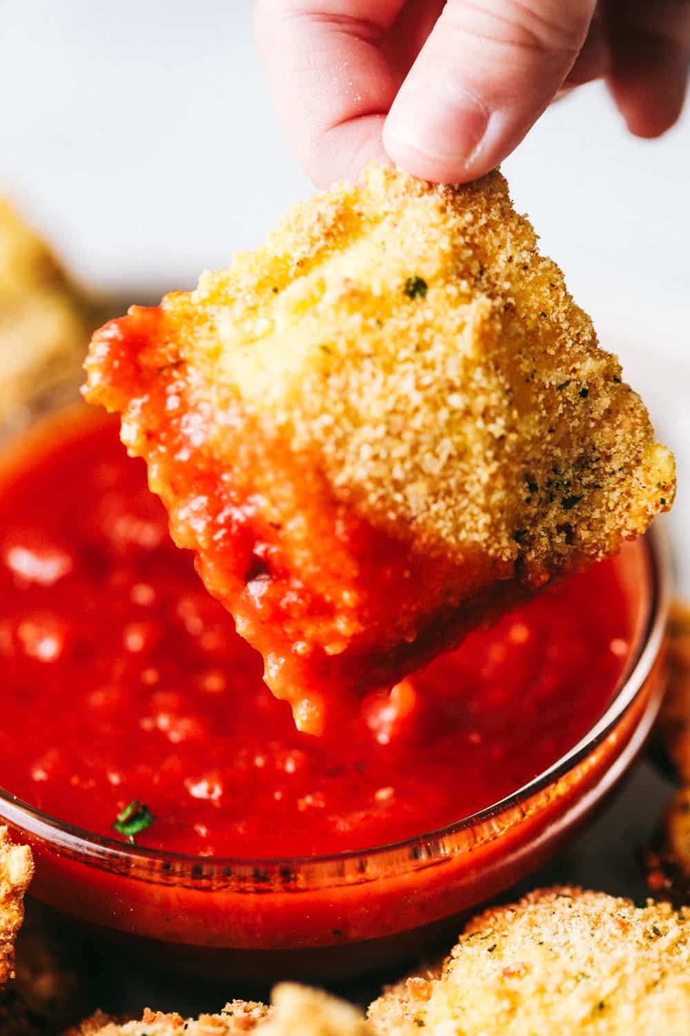 Dipping Crispy Baked Parmesan Ravioli.