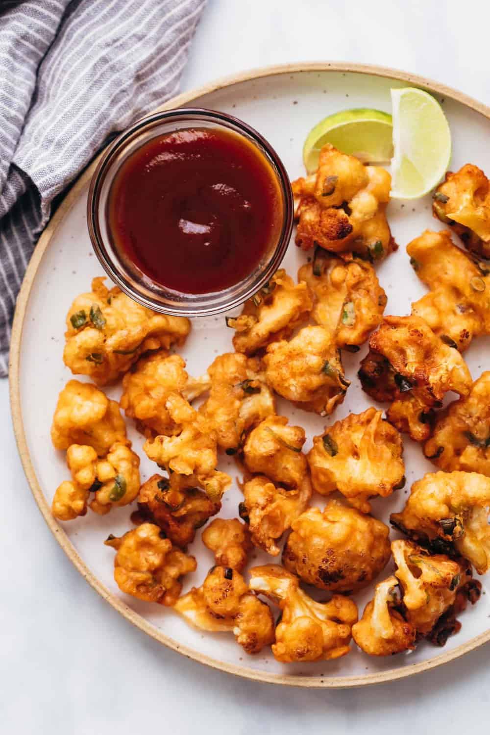 Cauliflower fritters served on a plate with ketchup