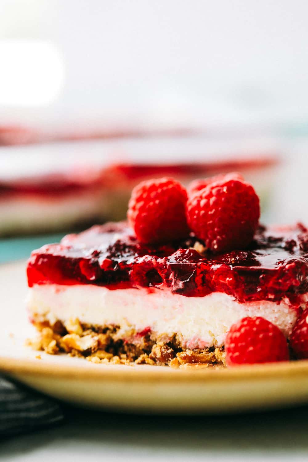 A slice of raspberry pretzel salad on a plate.