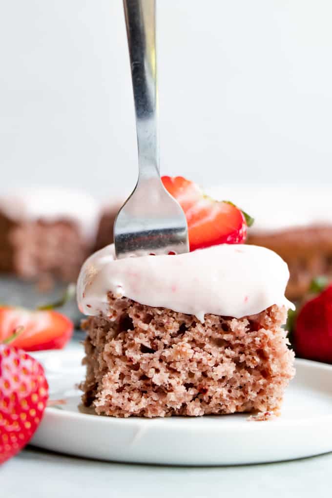 Slice of strawberry cake with a fork in it.