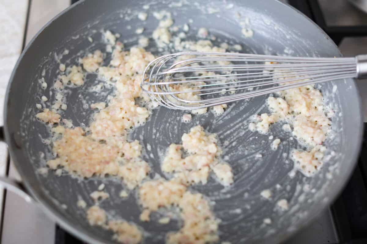 Third photo of the shallots and garlic cooking in a pan.