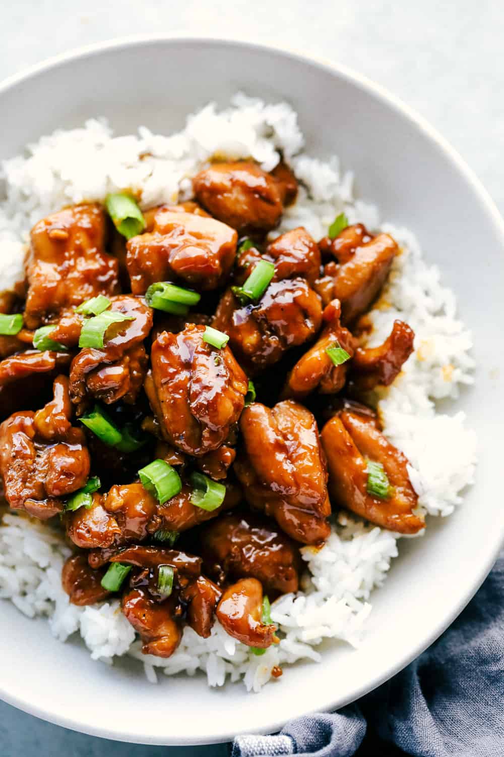 bourbon chicken over white rice and garnished with green onions