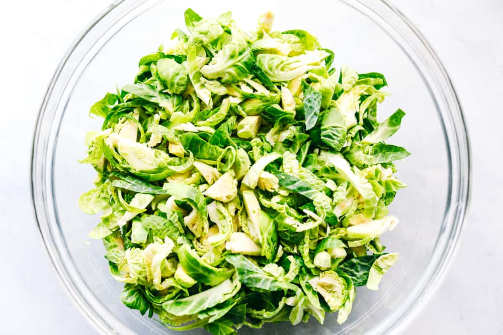 Shredded Brussel sprouts in a glass bowl. 