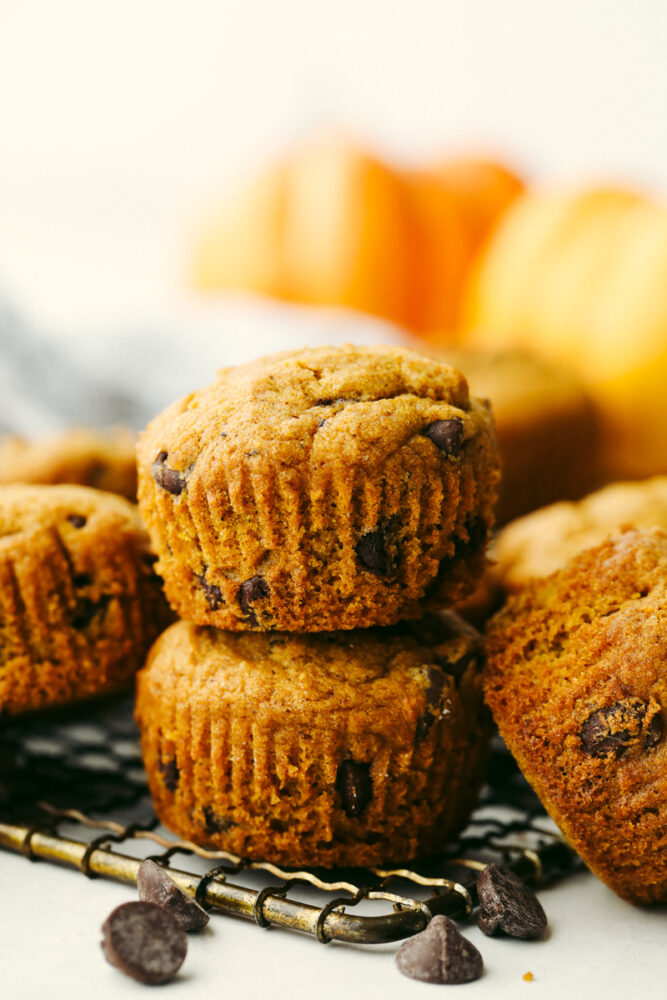 Pumpkin chocolate chip muffins stacked on top of each other.