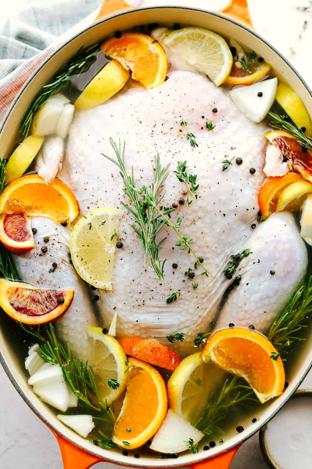 Turkey in a pot being submerged by water and other seasonings for a brine.