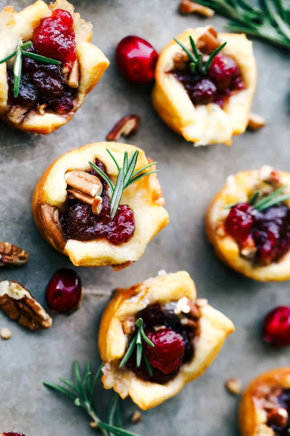 Baked cranberry pecan brie bites on a serving platter. 