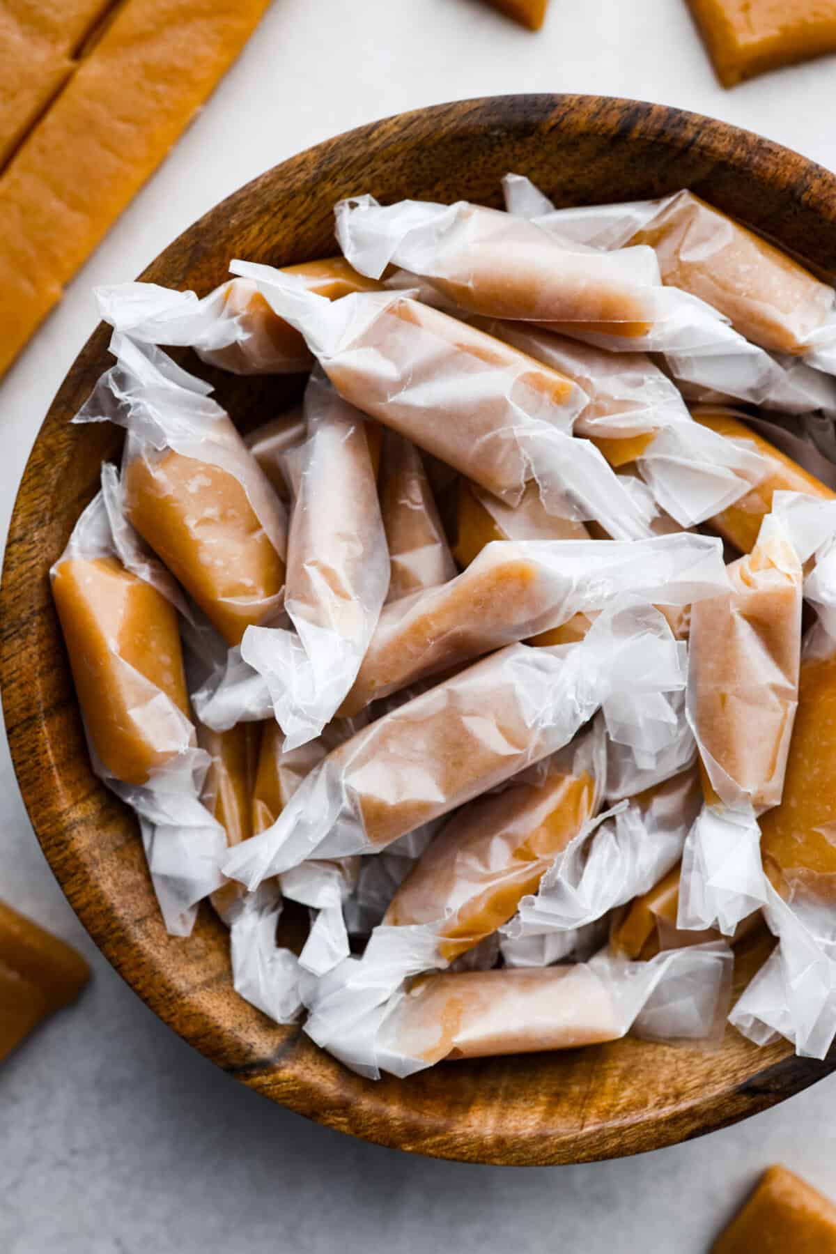 Overhead shot of a bowl of wrapped homemade caramels.