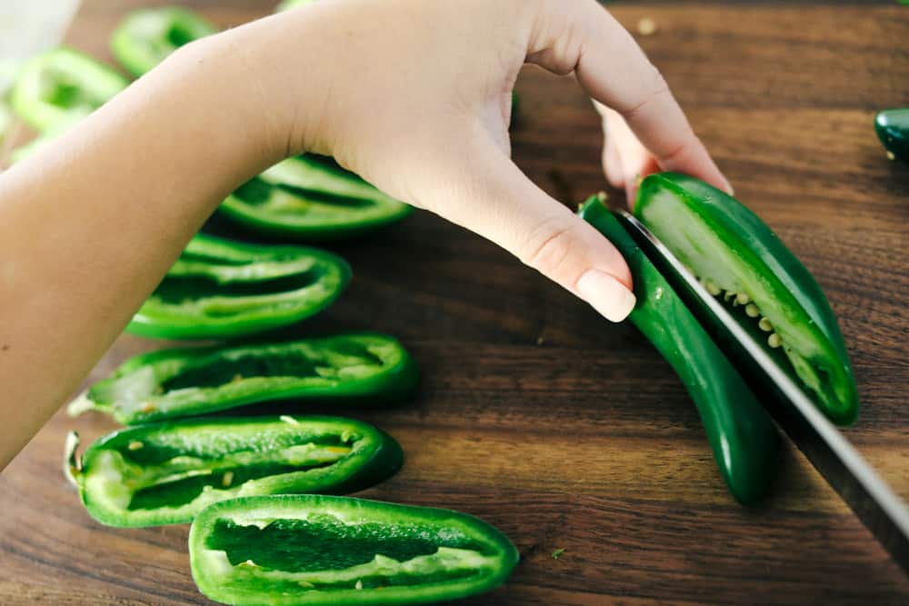 Slicing jalapeño peppers in half.