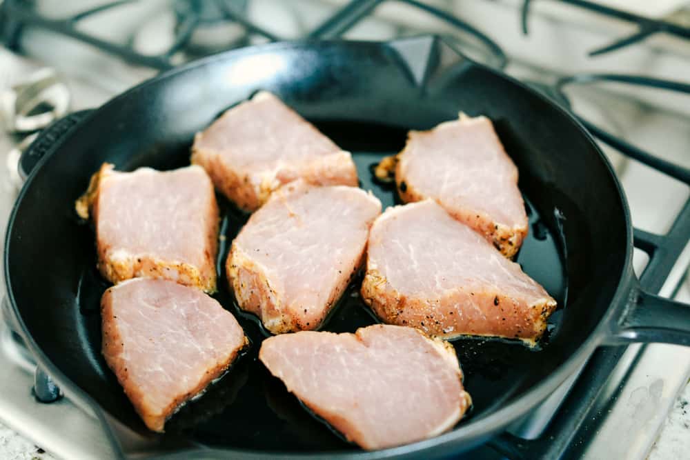 pork chops in a skillet cooking 