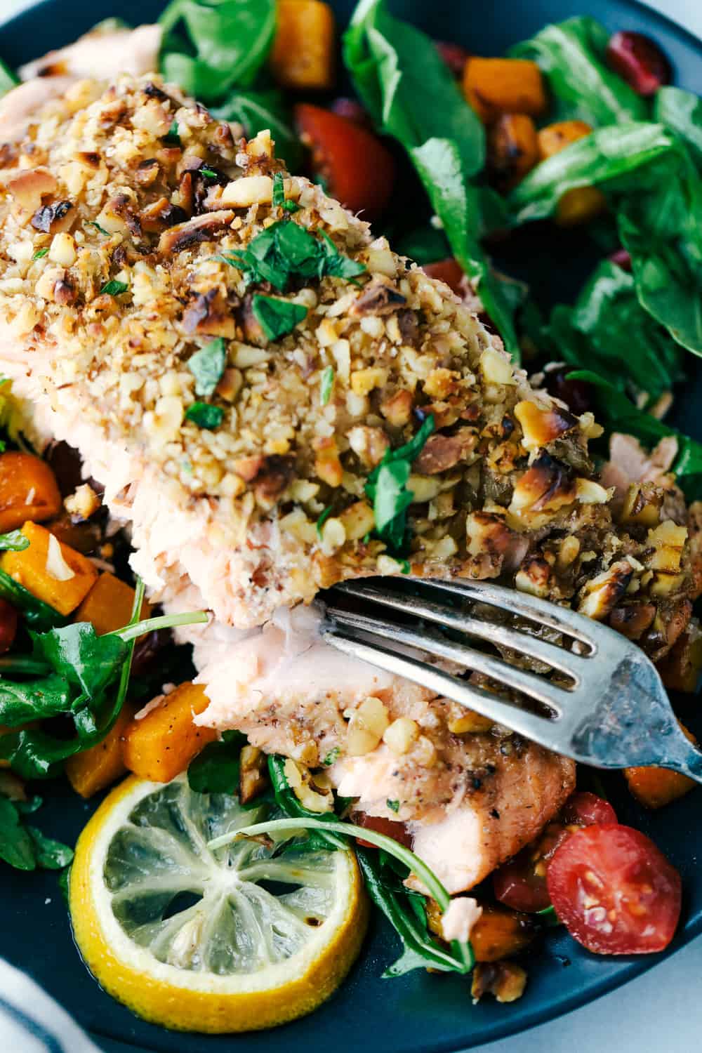 Walnut crusted maple salmon on a plate with a side salad. 