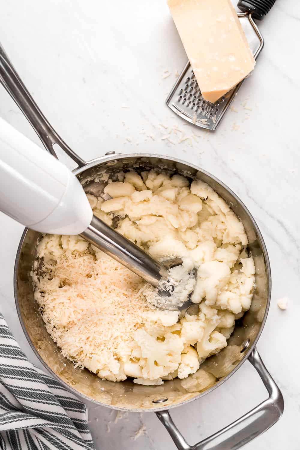 Cauliflower being mashed up in a pot