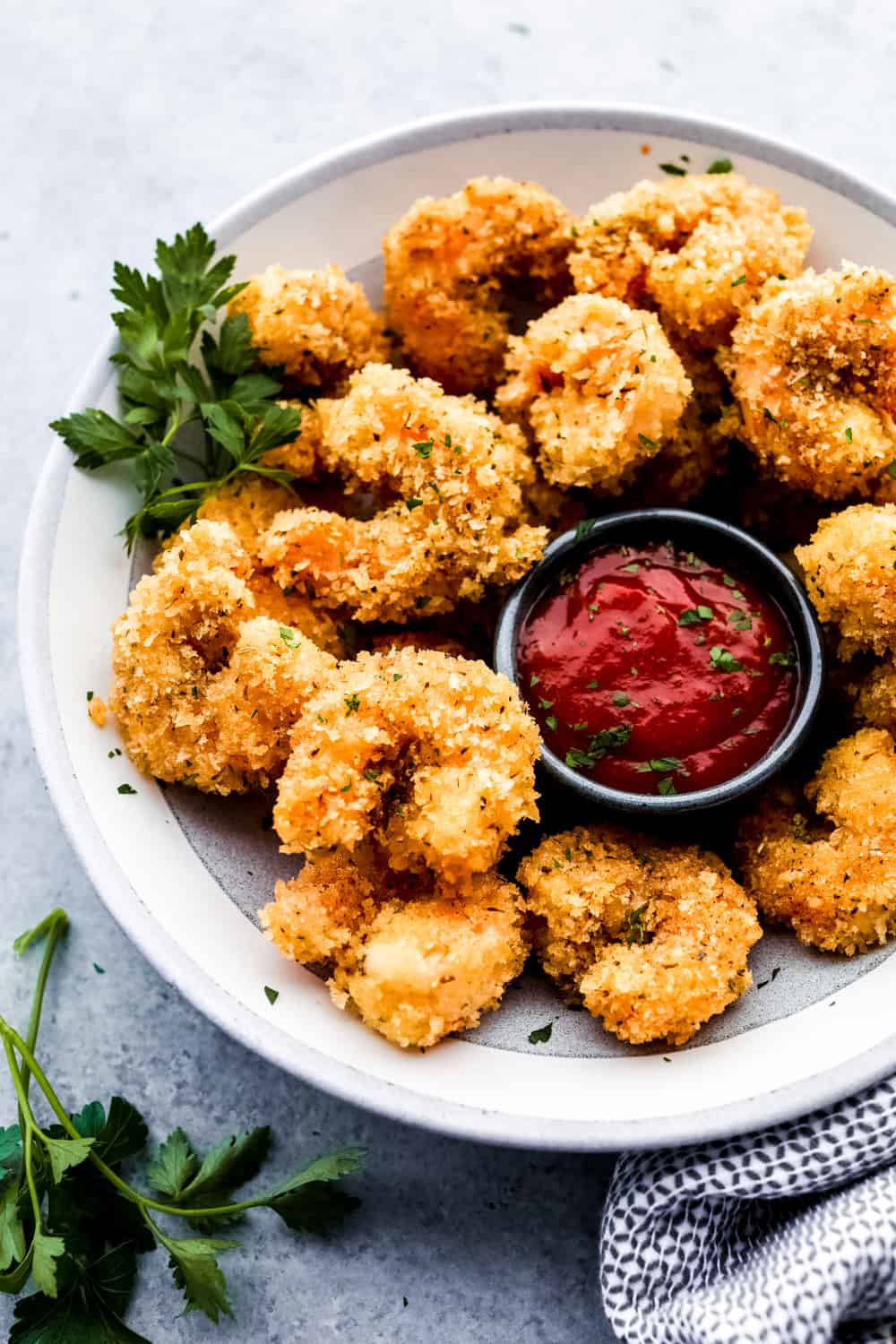 Cajun popcorn shrimp on a plate with cocktail sauce 