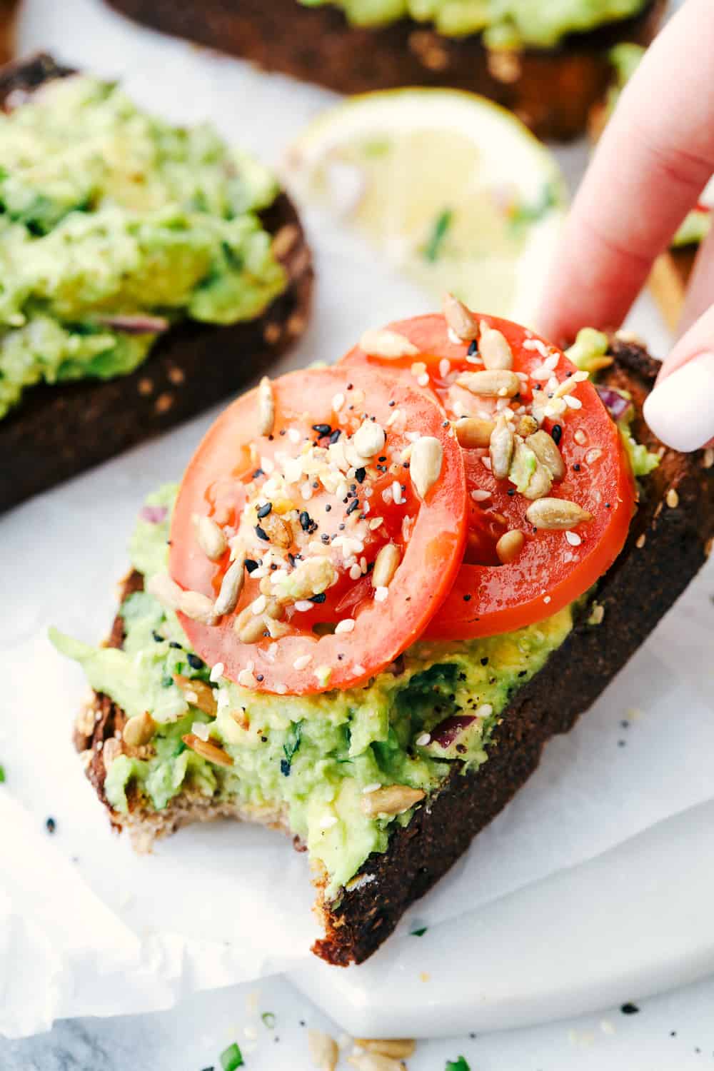 Avocado toast made with toasted bread, avocado mixture and tomato slices with everything bagel season. 