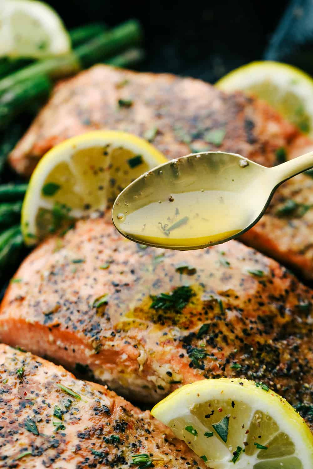 Brown butter lemon salmon with a spoon drizzling brown butter glaze over top of the salmon. 