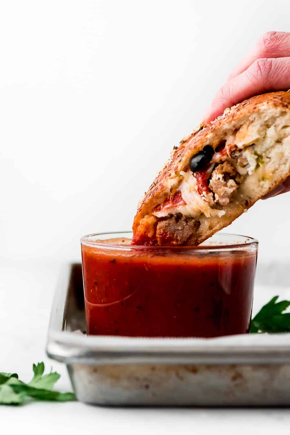 Dipping half a Calzone into marinara sauce.