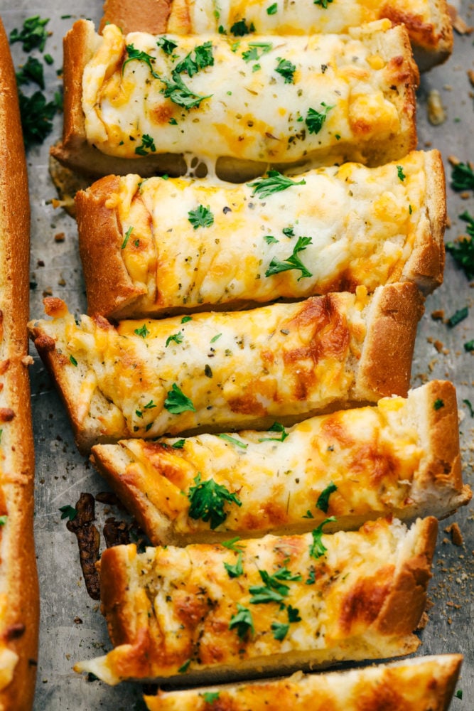 Sliced cheesy garlic bread on a pan. 