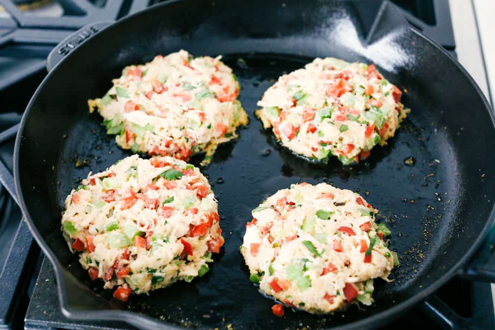 Chicken croquettes on a skillet being fried. 