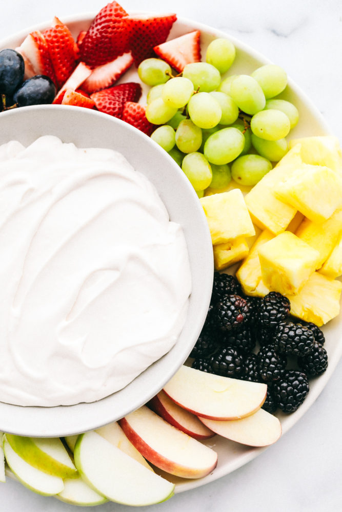 Fresh fruit prepared with a bowl of marshmallow cream cheese fruit dip. 