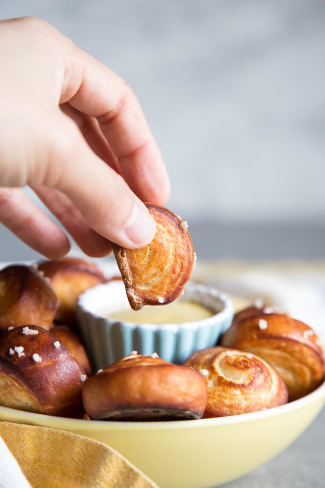 Dipping a pretzel bite into mustard sauce