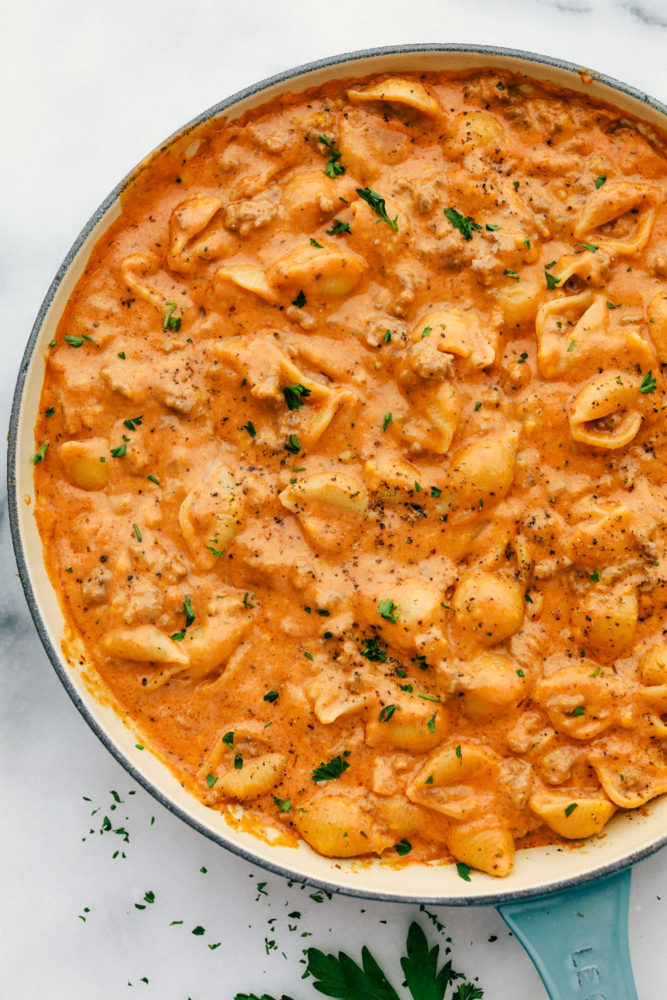 Cheesy beef and shells in a skillet cooked together. 