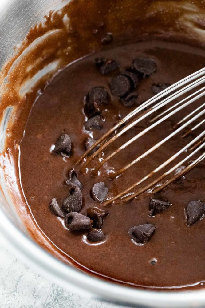 chocolate chips being mixed into a cake batter