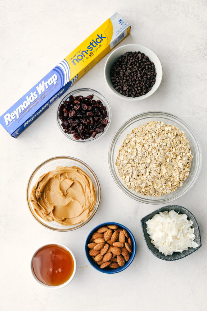 Granola bar ingredients in small bowls with Reynolds warp non stick aluminum foil in the photo. 