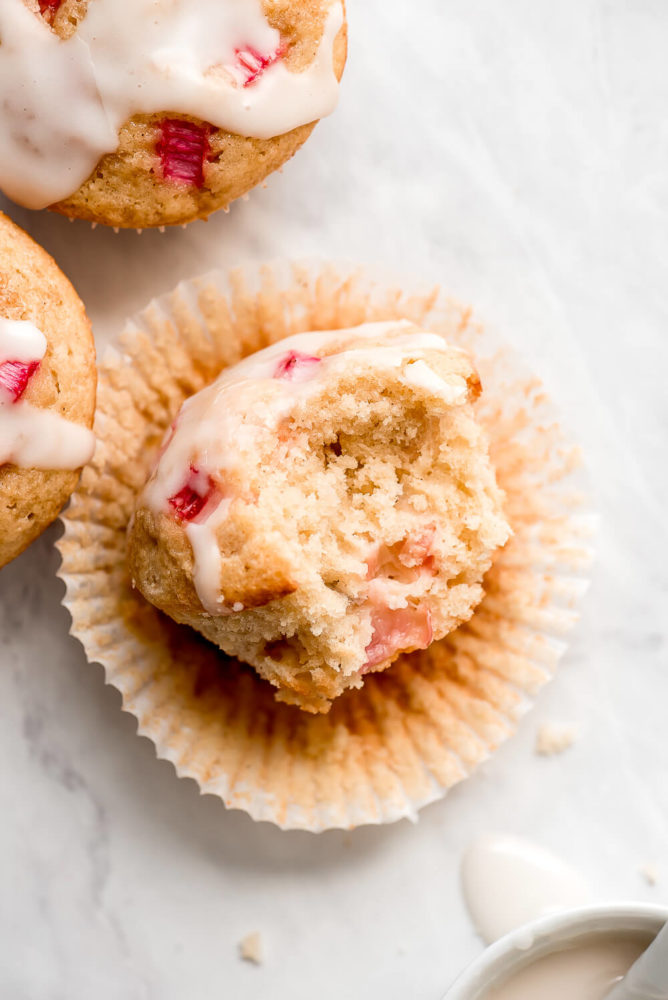 A muffin laying on its side with a bite taken out, showing the light and tender crumb.