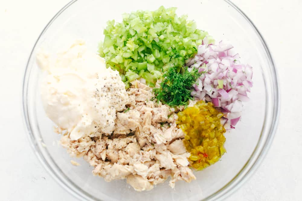 Tuna salad ingredients all separated in sections in the bowl. 