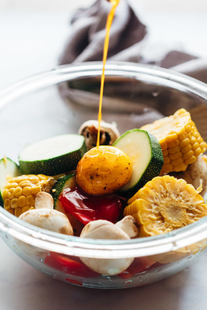 Pouring marinade over grilled vegetable kabobs