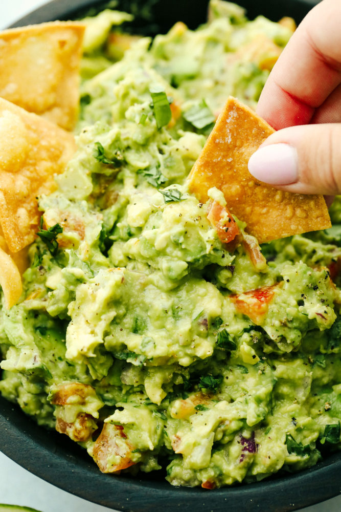 Dipping a chip into guacamole.