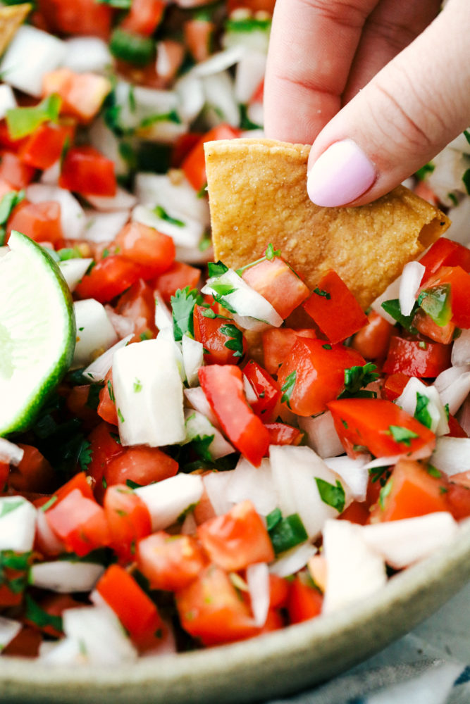 Dipping a chip into fresh pico de gallo.