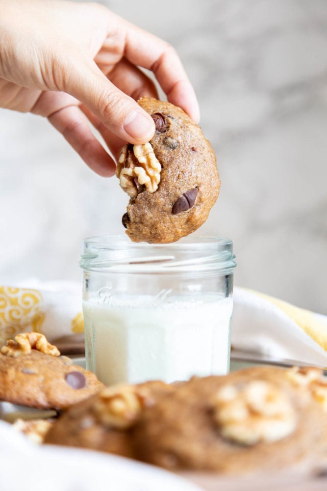 Dipping half a banana cookie in milk