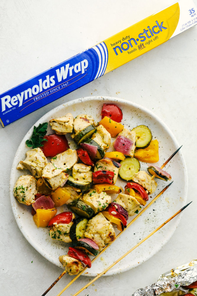 Chicken and vegetables on a white plate with Reynolds wrap box on the side. 