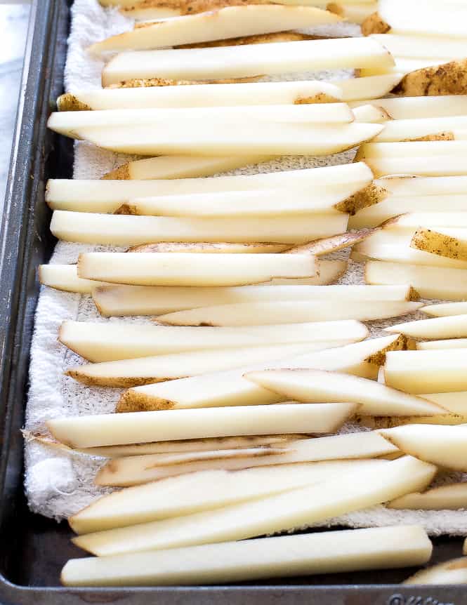 Sliced potatoes in the shape of French fries ready to bake. 