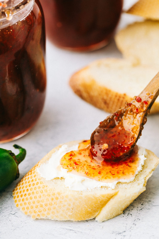 Spreading jalapeno jelly of bread with butter. 