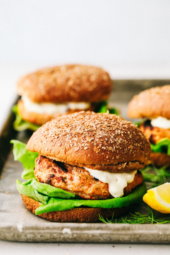 Finished salmon burgers on a tray.