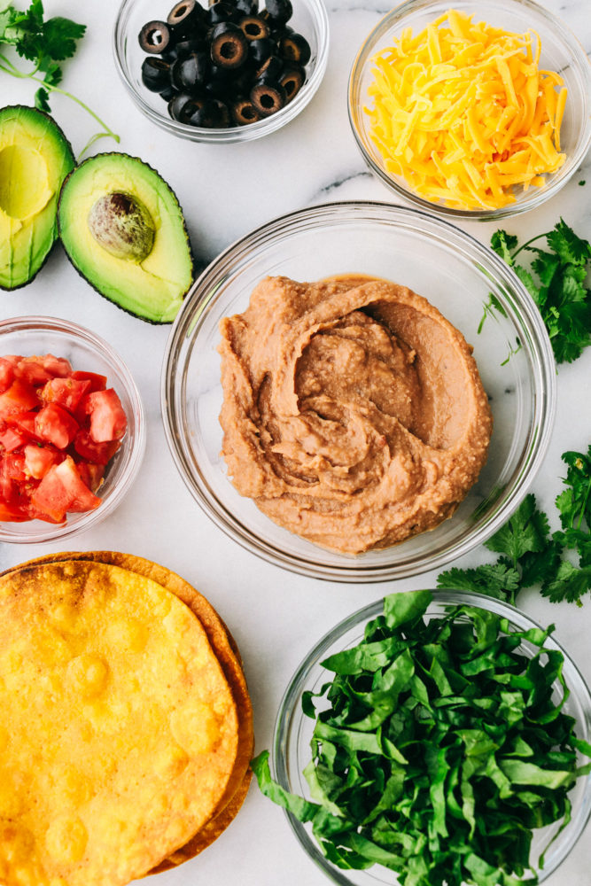 Optional toppings for tostadas in clear, glass bowls. 