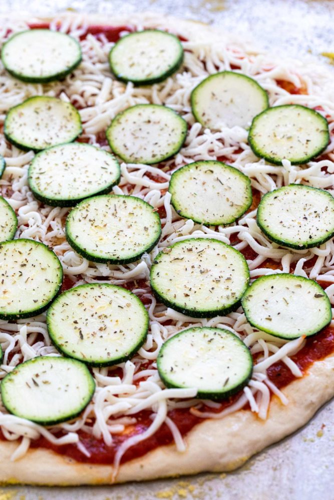 Thin slices of zucchini layered on top of a pizza