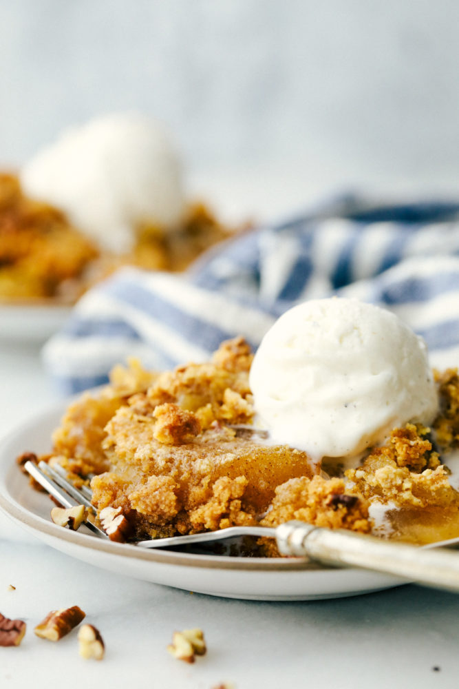 Apple dump cake on a plate with a fork. 