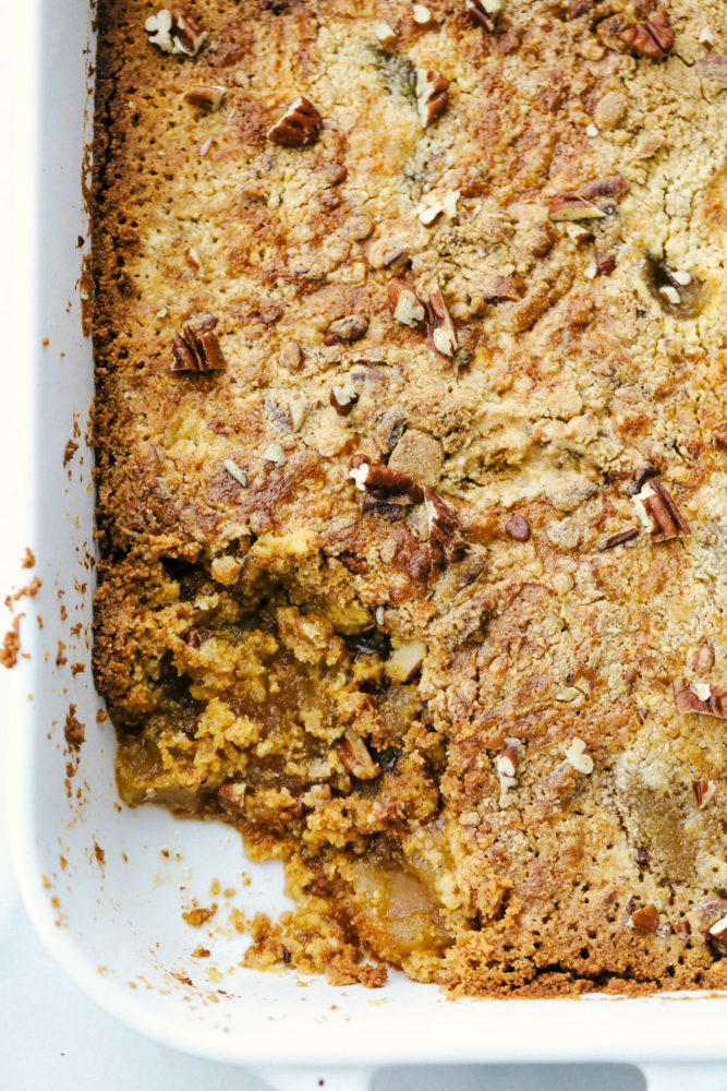 Baked apple dump cake in a baking pan with a slice taken out. 