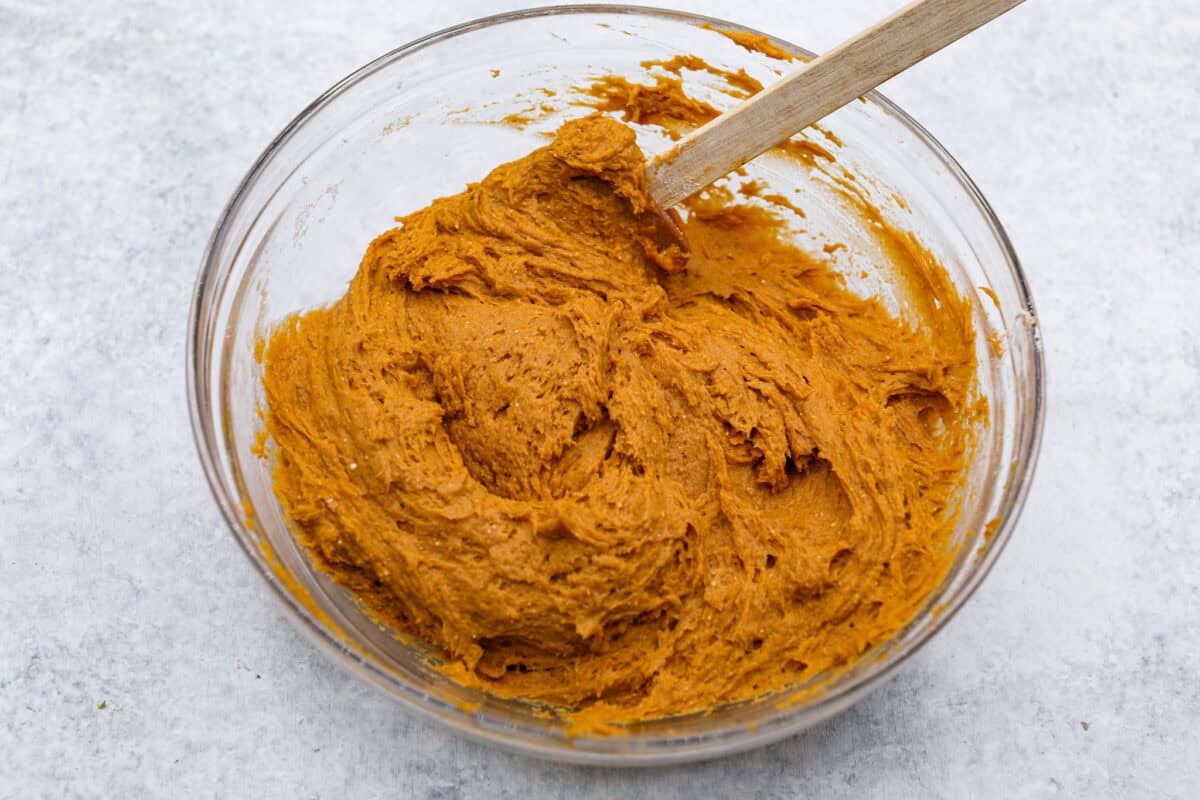 Overhead shot of pumpkin puree mixed in with the spiced cake mix. 