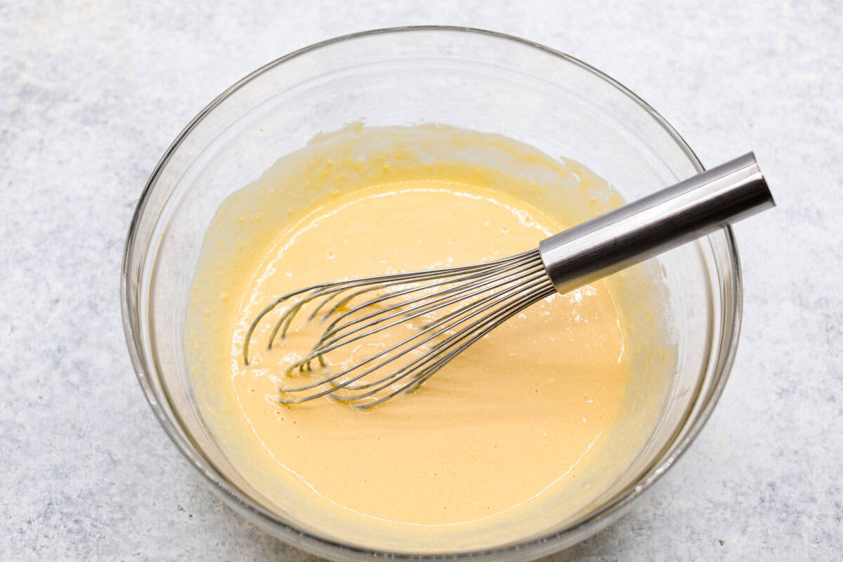 Overhead shot of the melted butter, sour cream, sugar, brown sugar, eggs and vanilla whisked in a bowl. 