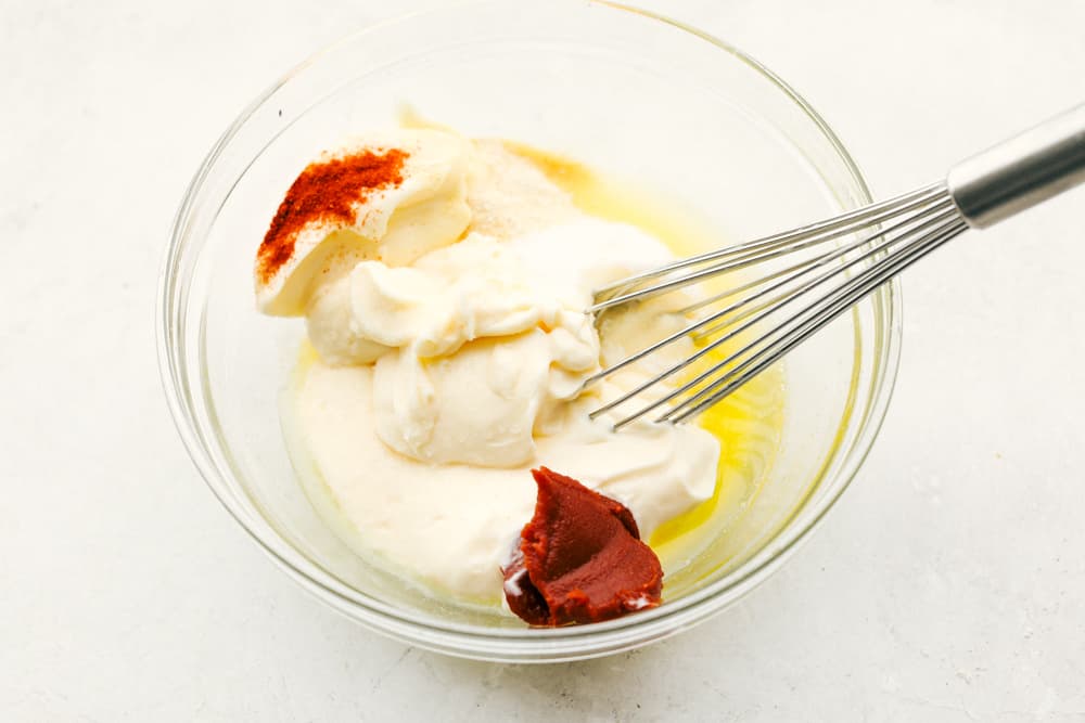 Mixing the ingredients together in a glass bowl with a whisk. 