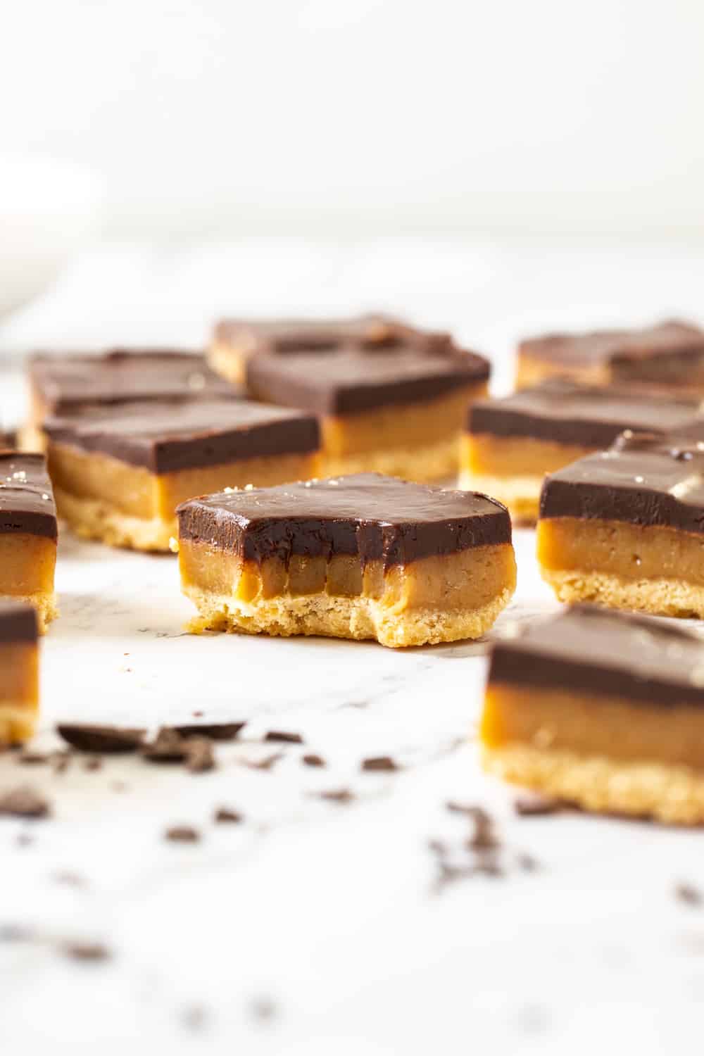 Closeup of a slice of millionaire shortbread with a bite mark in it