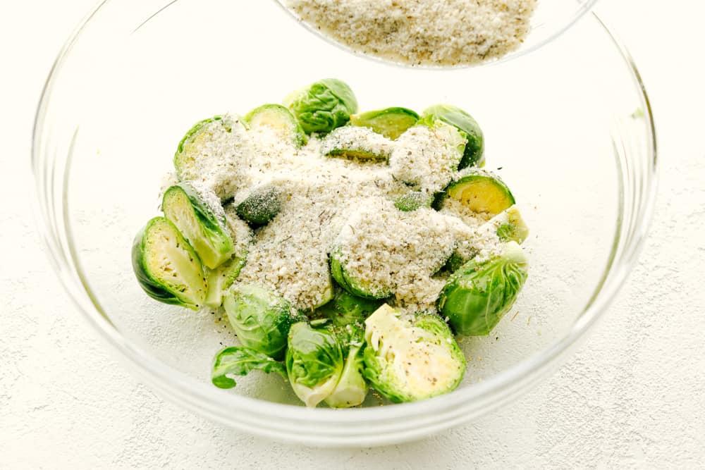 Coating the brussel sprouts with parmesan and seasonings. 