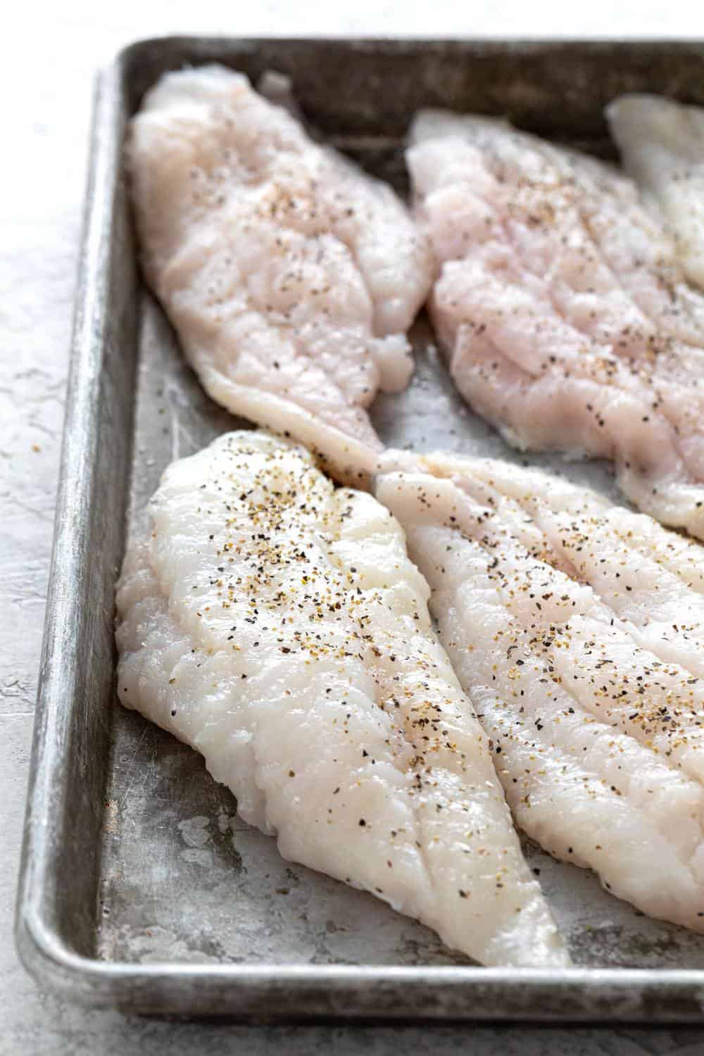 seasoned fillets of fish in a pan