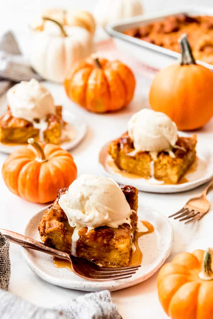 Slices of pumpkin bread pudding with ice cream on top.